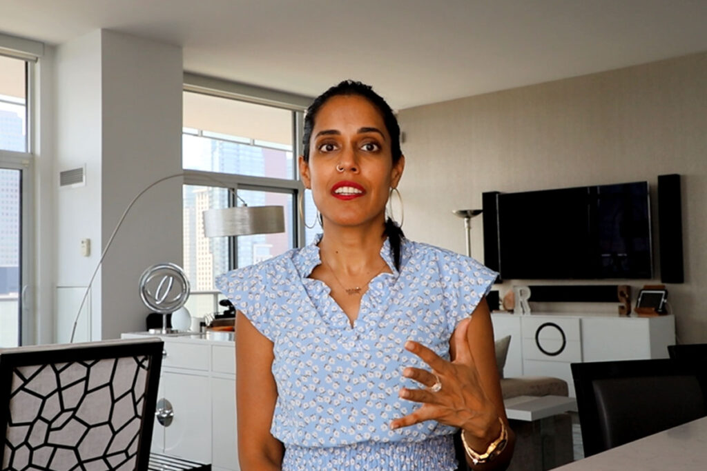 Ritu Bhasin speaking with her right hand raised.